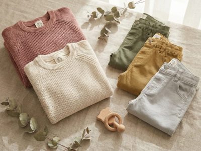 Bio-Baumwoll-Kinderkleidung auf Leinenhintergrund — GOTS-zertifiziert